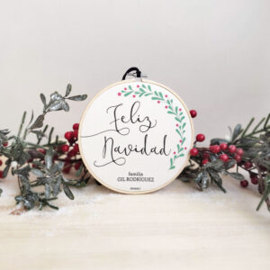 CORONA NAVIDAD PERSONALIZADA CASTELLANO APOYADA SOBRE RAMAS ACEBO
