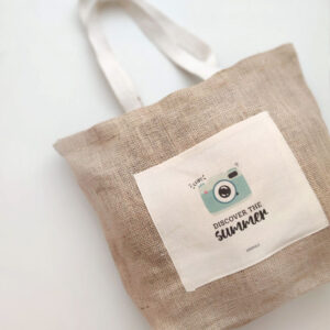 BOLSO YUTE DISCOVER SUMMER COLOCADO SOBRE FONDO GRIS